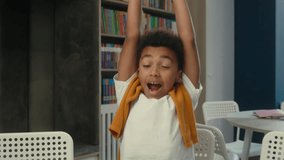 African American little boy son child kid pupil school student schoolboy at desk yawning stretching hands tired exhausted sleepy boring education studying in classroom writing fatigue sleeping weary - Powered by Shutterstock - Get 15% off with code: PIKWIZARD15