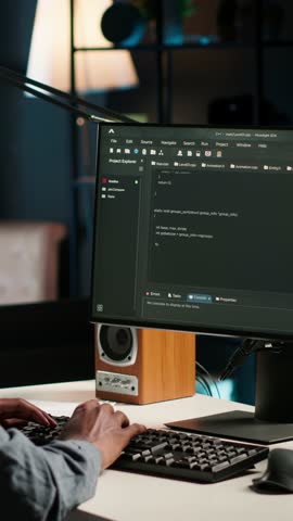 Vertical Video Black man programmer manages code and scripts in artificial intelligence and machine learning on dual monitors computer setup. Male freelancer uses pc to guarantee cyber security