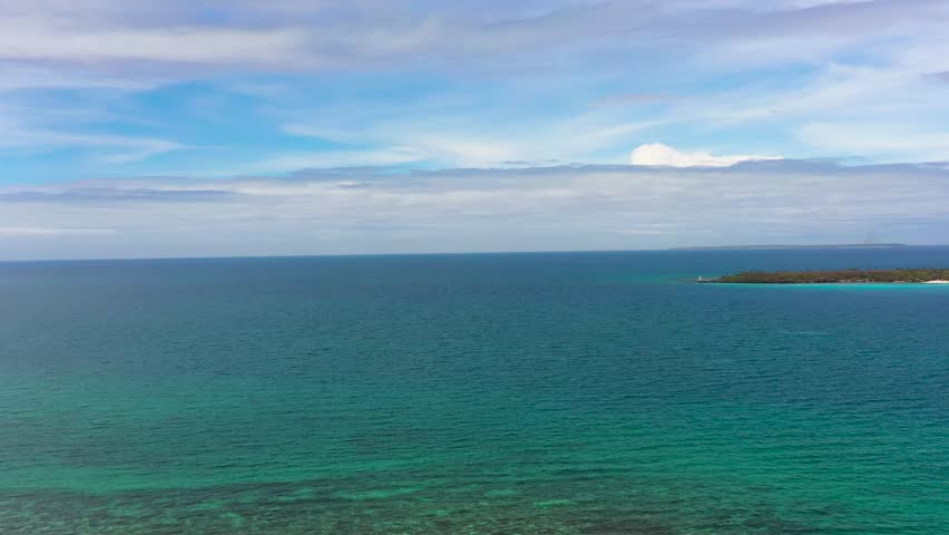 Blue sea and corals in Bantayan. Virgin Island with sandy beach. Blue sky and clouds. Cebu, Philippines.