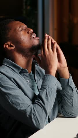 Vertical Video Black developer feeling exhausted and trying to meet task deadline, working hard to finish report in time and dealing with a headache. African american guy being under stress with