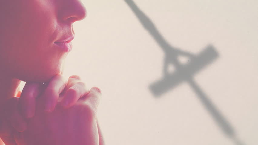 Praying person holding crucifix overlay, creating spiritual and reflective animation. Spirituality, faith, meditation, worship, reflection, religion