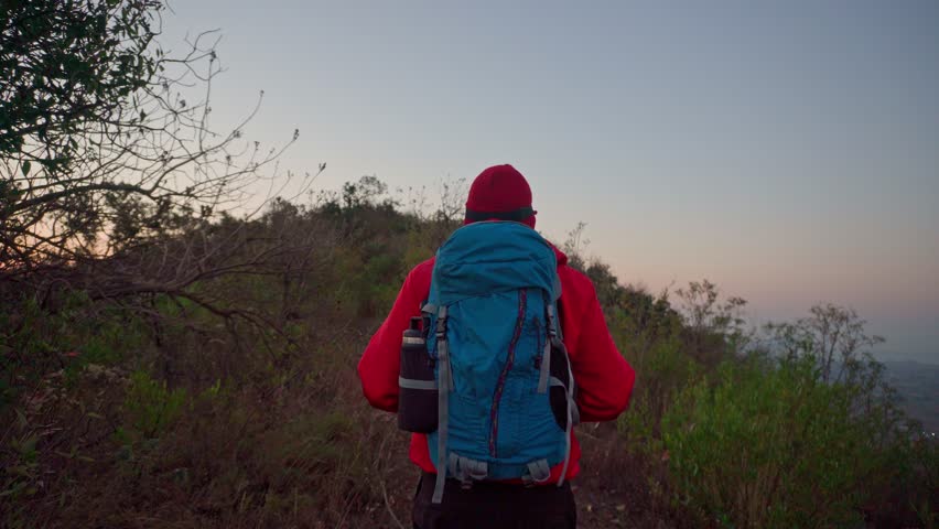 Hiker walking on a trail at dusk