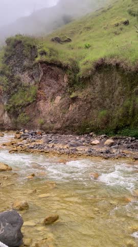 Sulfur river in the forest surrounded by green hills