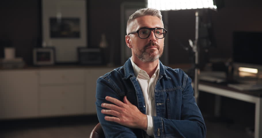 Set, man and preparation for film, production or interview with mature celebrity. Creative, fashion and art director in studio getting ready with glasses for tv show, media and live stream broadcast