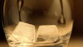 Scotch Whiskey Being Poured into a Tumbler Glass with Big Ice Cubes in Slow Motion. Chilled Alcoholic Beverage Served in Bars and Restaurants. - Powered by Shutterstock - Get 15% off with code: PIKWIZARD15
