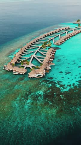 Vertical Aerial shot of tropical island paradise W hotel Maldives Sapphire blue waters and atolls surround the luxurious resort. 