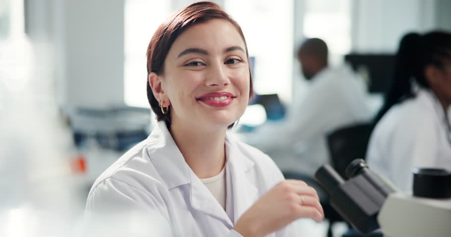 Science, woman and face with microscope in laboratory for vaccine development, medical research or innovation. Scientist intern, person or happy for microbiology, DNA testing or healthcare experiment