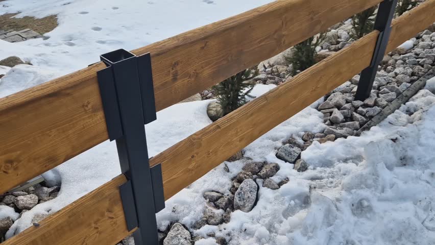 a wooden fence in combination with evergreen shrubs is a natural solution for fencing a garden at a cottage