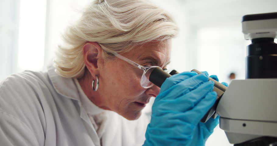 Mature woman, microscope and notes at lab, science or review results for medical research. Person, tools and lens with zoom, bacteria and problem solving for virus, pharmaceutical or bird flu vaccine
