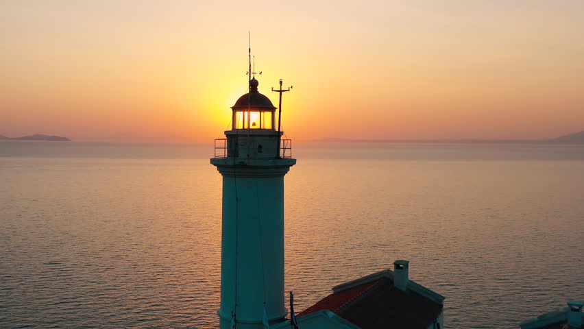A Beautiful Lighthouse Standing at Sunset Over the Calm and Serene Sea Waters