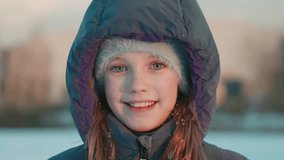 Redheaded cute female girl wearing winter coat and furry hat, standing amid snowy urban park, embodying hope through resilient expression. Cheerful kid child face  - Powered by Shutterstock - Get 15% off with code: PIKWIZARD15