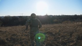Rear view of ukrainian army soldier running through field at sunny day. Young male military in uniform jogging among meadow. Victory against russian aggression. Invasion of territory Ukraine. Slow mo - Powered by Shutterstock - Get 15% off with code: PIKWIZARD15