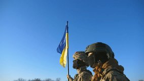 Female and male soldier of ukrainian army standing at peak of hill with raised flag of Ukraine. Military couple in camouflage uniform holds hands of each other looking at blue sky with sun. Dolly shot - Powered by Shutterstock - Get 15% off with code: PIKWIZARD15