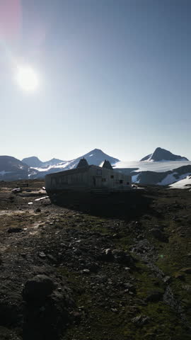Vertical aerial shot of Rabothytta cabin, situated on the edge of Okstindbreen glacier, with views of the Okstindan mountain range in the distance. Korgen, Norway