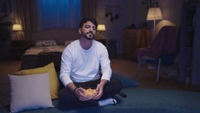 A man lounges at home, eating popcorn and struggling to stay awake as he fights off sleep while watching TV.
 - Powered by Shutterstock - Get 15% off with code: PIKWIZARD15