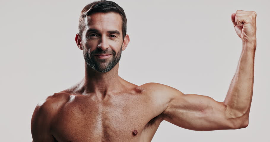 Flex, face and man in studio topless for fitness, masculinity or strength. Bicep, exercise and muscle with body of shirtless model on white background for training, confidence or workout results