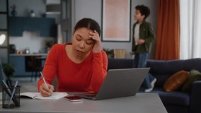 Stress busy African American business woman mother businesswoman freelancer mom female girl using laptop working at home writing notes suffer with noisy active boy child kid son jumping couch playing - Powered by Shutterstock - Get 15% off with code: PIKWIZARD15
