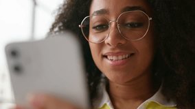 Close up face African American woman female student girl in school university indoors businesswoman business chat holding mobile phone smiling happy carefree using smartphone app chat social media net - Powered by Shutterstock - Get 15% off with code: PIKWIZARD15