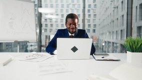 Inside modern office of big company, African American man working with laptop. Startup owner or beginner businessman, financial analyst and CEO, head of international corporation sitting at table - Powered by Shutterstock - Get 15% off with code: PIKWIZARD15
