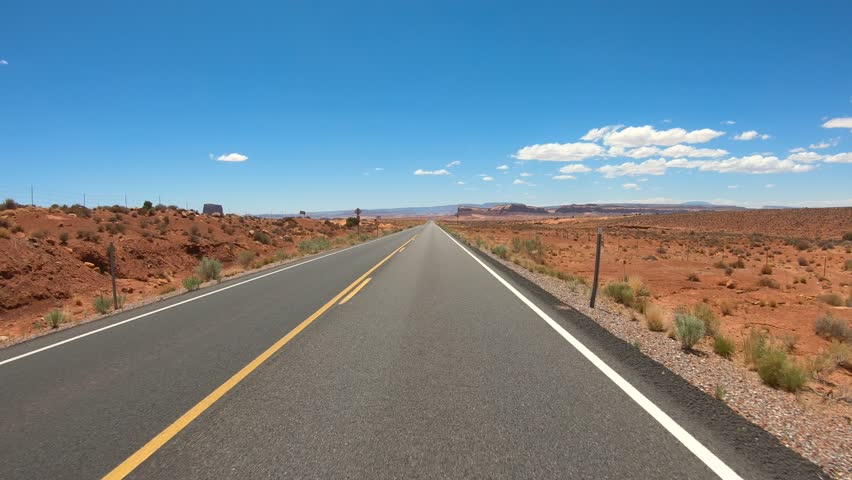Front Facing Driving Plate Monument Valley Western USA. POV Highway Desert Highway Towards Mountains Daytime Blue Sky