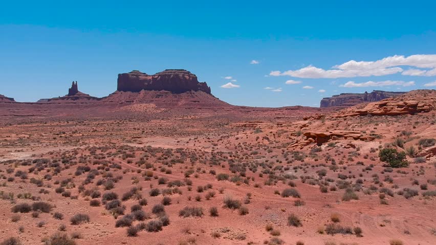 Monument Valley Drone Red Western Desert Landscape. Blue Sky Sunny Day Scattered Bushes No People