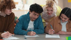 Four school Caucasian students happy smiling talk learn pupils studying male female write homework teamwork at table study learning men women girls guys writing talking cooperation communicate college - Powered by Shutterstock - Get 15% off with code: PIKWIZARD15