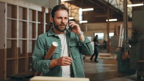 Carpentry, woodwork and man on a phone call in factory for furniture production, client orders and contact. Construction, workshop and person on smartphone talking for timber, lumber or manufacturing - Powered by Shutterstock - Get 15% off with code: PIKWIZARD15