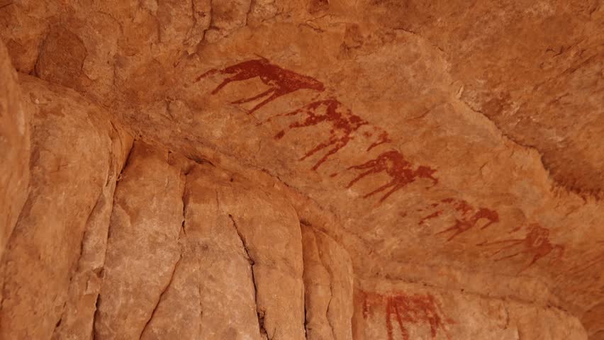 Neolithic rock art. Rock painting of a camel with rider. Tadrart Rouge. Tassili N'Ajjer National Park. Sahara Algerian Desert. Illizi Province, Djanet, Algeria, Africa