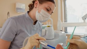 Blonde Woman Dentist with Assistant Treat Teeth of Female Patient with Special Instrument. Treatment of Caries and Plaque in Dental Clinic. Concept of Medicine and Healthcare. Slow Motion. - Powered by Shutterstock - Get 15% off with code: PIKWIZARD15