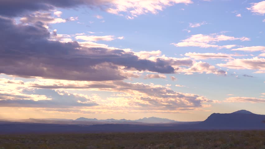 Timelapse Sunrise Clouds Moving Across Sky at Chisos Mountains Big Bend National Park Texas. Sun Rays Enter From Left
