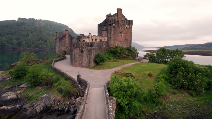 Epic Aerial Eilean Donan Castle Scotland with Moat Flies From Wide Over the Top, Just Barely Missing it at Sunrise