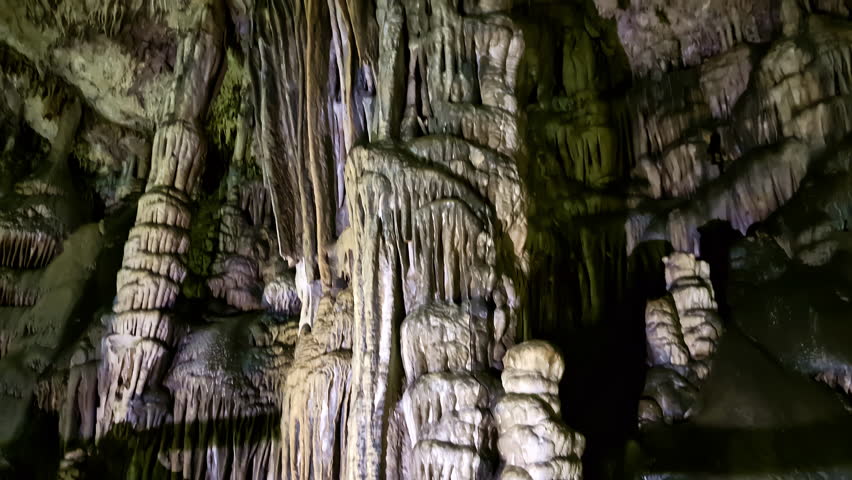 Landscape pan of human shadow walking in dark underground cave chambers passageway of Diktaion Andron in Psychro village Crete Greece stalactites stalagmites