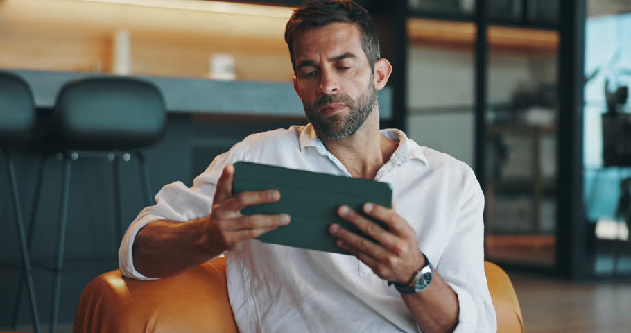 Home, confused and man with tablet, lounge and doubt for payment to streaming site and thinking. Living room, browsing and cancellation of subscription to app, frown and person with tech in house