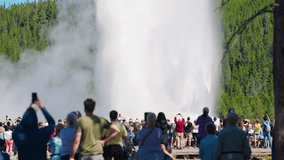 Visitors gather at Yellowstone to witness Old Faithful’s powerful eruption, capturing the iconic geyser shooting steam and water skyward. - Powered by Shutterstock - Get 15% off with code: PIKWIZARD15