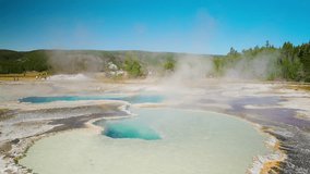 Yellowstone’s vibrant hot spring bubbles and steams, its vivid colors contrasting with the warm summer air and natural surroundings. - Powered by Shutterstock - Get 15% off with code: PIKWIZARD15