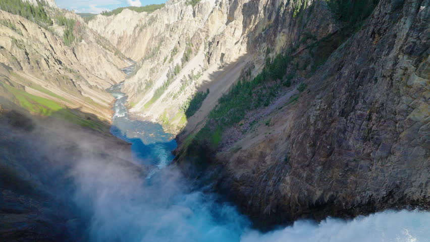 An incredible waterfall cascades into Yellowstone River Valley, creating a breathtaking natural wonder surrounded by rugged terrain and scenic beauty.