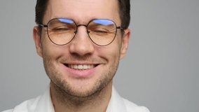 Smiling man wearing glasses in a light-colored shirt against a neutral background - Powered by Shutterstock - Get 15% off with code: PIKWIZARD15