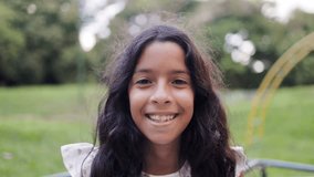 Happy latin female child smiling on camera with kid park on background. Childhood life concept - Powered by Shutterstock - Get 15% off with code: PIKWIZARD15