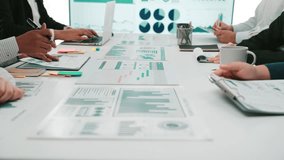 A diverse group of professionals collaborates in a modern office, analyzing financial data displayed in reports and charts, showcasing teamwork and strategic planning. SACTR - Powered by Shutterstock - Get 15% off with code: PIKWIZARD15