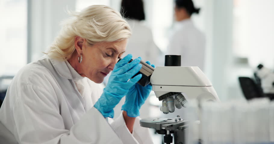 Science, lab and mature woman with microscope for research, medical study and discovery. Healthcare, pharmaceutical and scientist with equipment for vaccine, microbiology and experiment for medicine