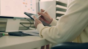 Businesswoman, accountant, analyst working from home uses a digital tablet and stylus while analyzing financial documents on her desk and computer screen.   - Powered by Shutterstock - Get 15% off with code: PIKWIZARD15