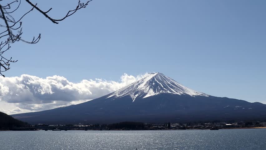 Mount Fuji surrounded by a lake and the blue sky in the background in Japan