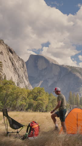 A man sets up a cozy camp in the breathtaking and stunning landscapes of Yosemite National Park, surrounded by majestic mountains, vibrant nature, and providing an escape into the wild