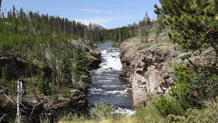 Pan and dolly move to reveal a waterfall on the Gardner River in Yellowstone