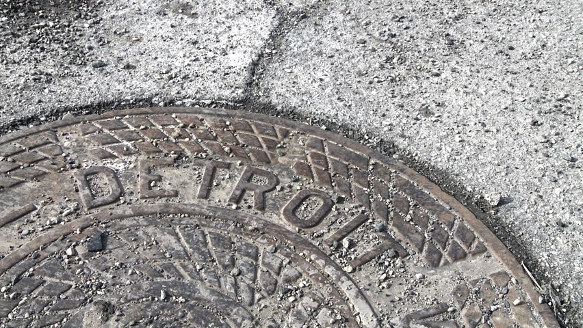 Close up of feet in nice business shoes walking over a manhole cover with the