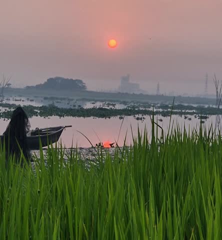 Sunset in the sky and wooden boat next to green grass