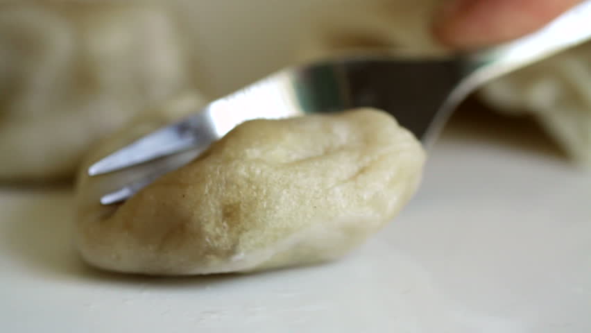 Close up on a steamed dumpling which is cut in half with a fork. Shot with a