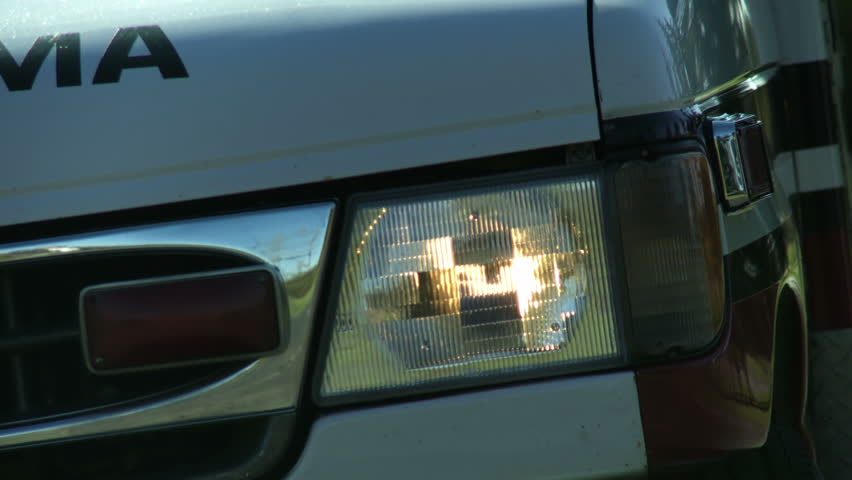 Flashing hazard lights on an ambulance at a canted camera angle. Loopable clip.