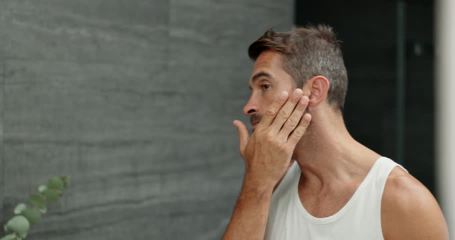 Beard, hair care and man with beauty, mirror and grooming with treatment for shine. House, reflection and person with skincare, hygiene and maintenance with health spa facial, aesthetic and bathroom