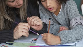 Caucasian mother and African American daughter studying at home, doing homework in cosy white room. Parent teach, child school girl learn knowledge, write exercise read book. Education for children - Powered by Shutterstock - Get 15% off with code: PIKWIZARD15
